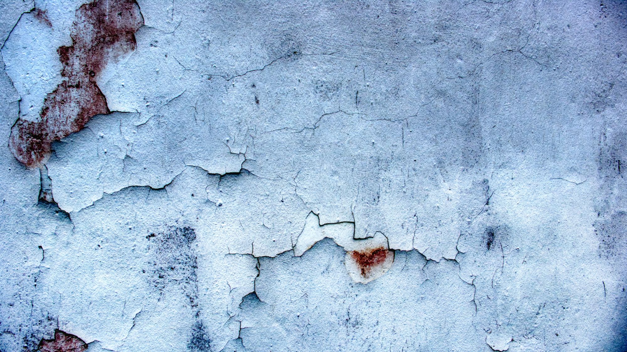 Image Description: A clearly aged wall with peeling paint and spots of rust